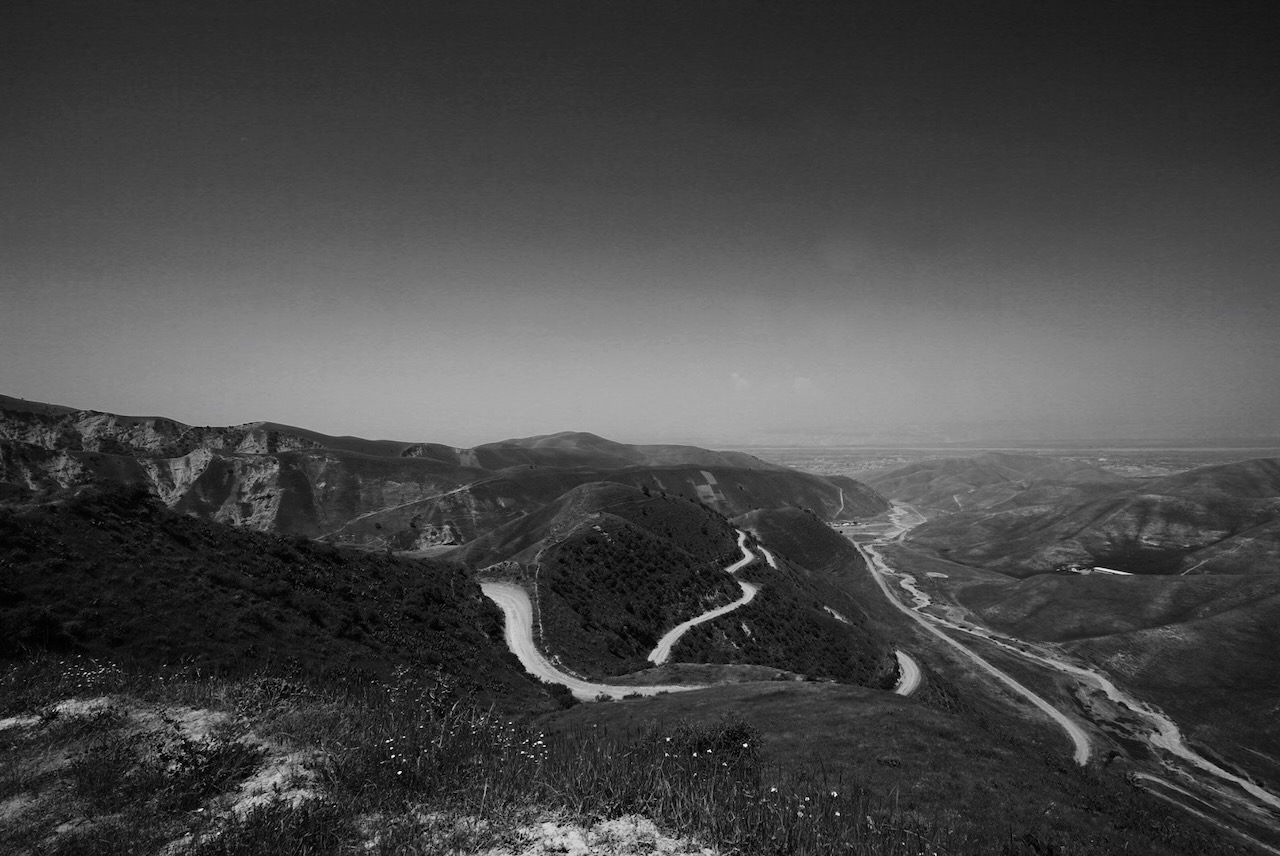 A switchback road winding through dry hills