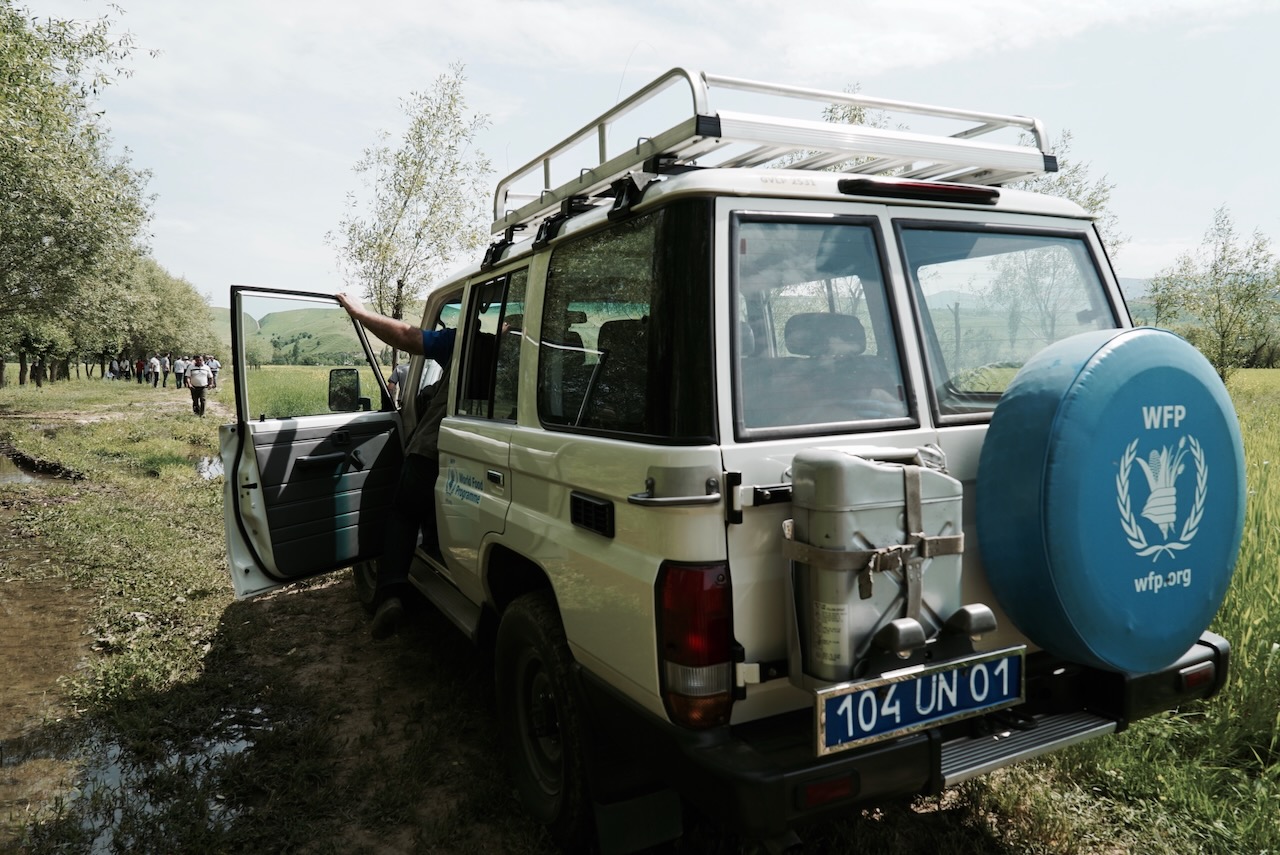 A World Food Programme land cruiser parked on a muddy track