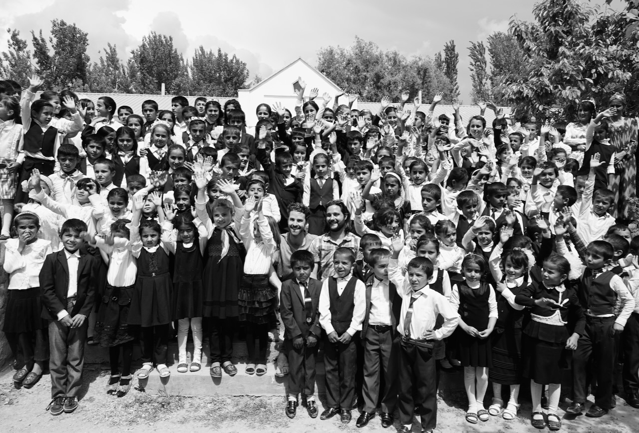 Schoolchildren and visitors gathered on the steps of a rural school