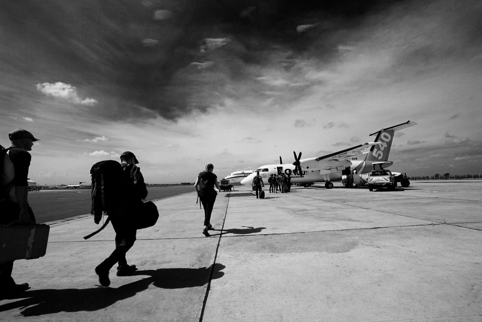 The crew walking a tarmac toward a small propeller plane