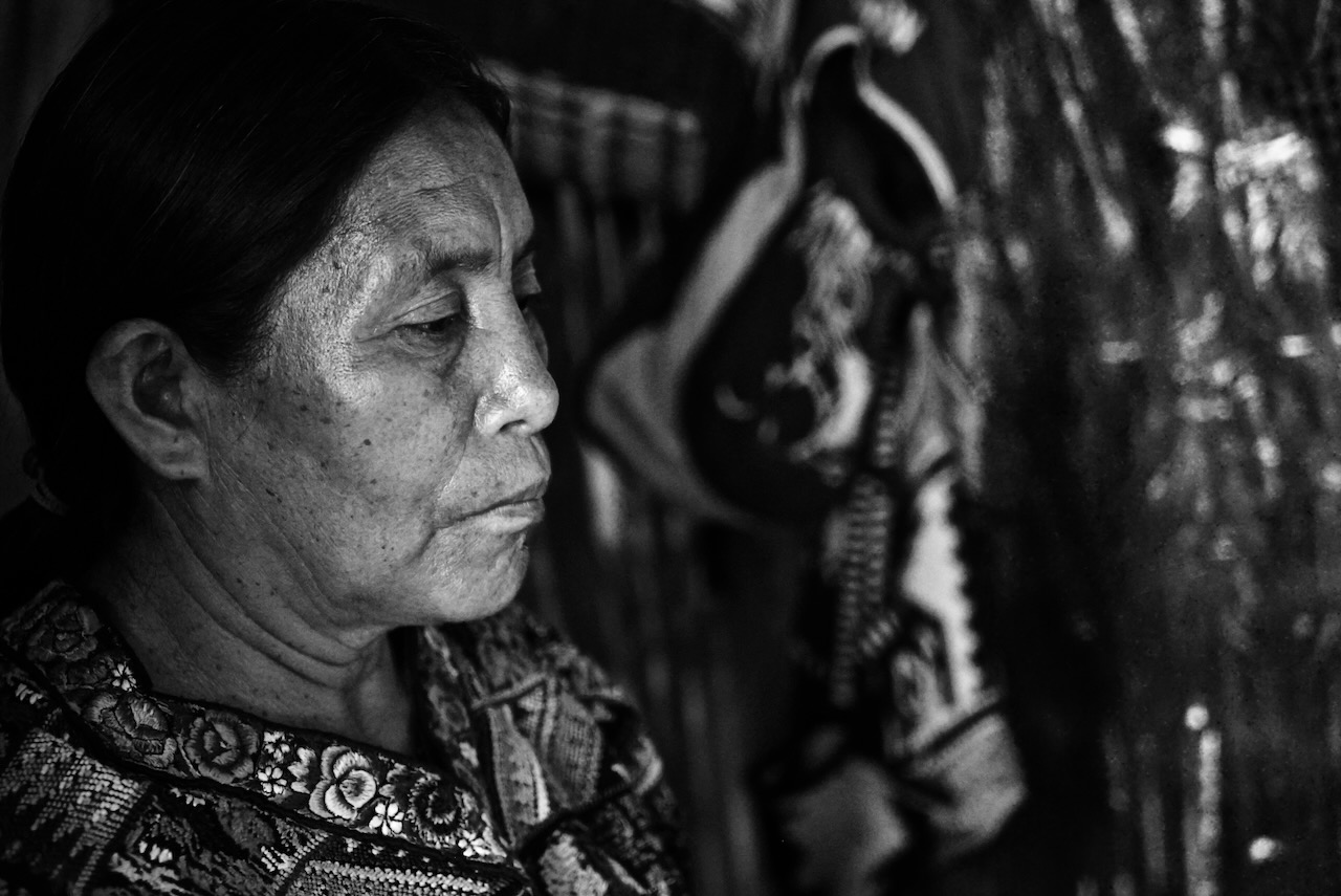 An older Maya woman in profile, in embroidered clothing
