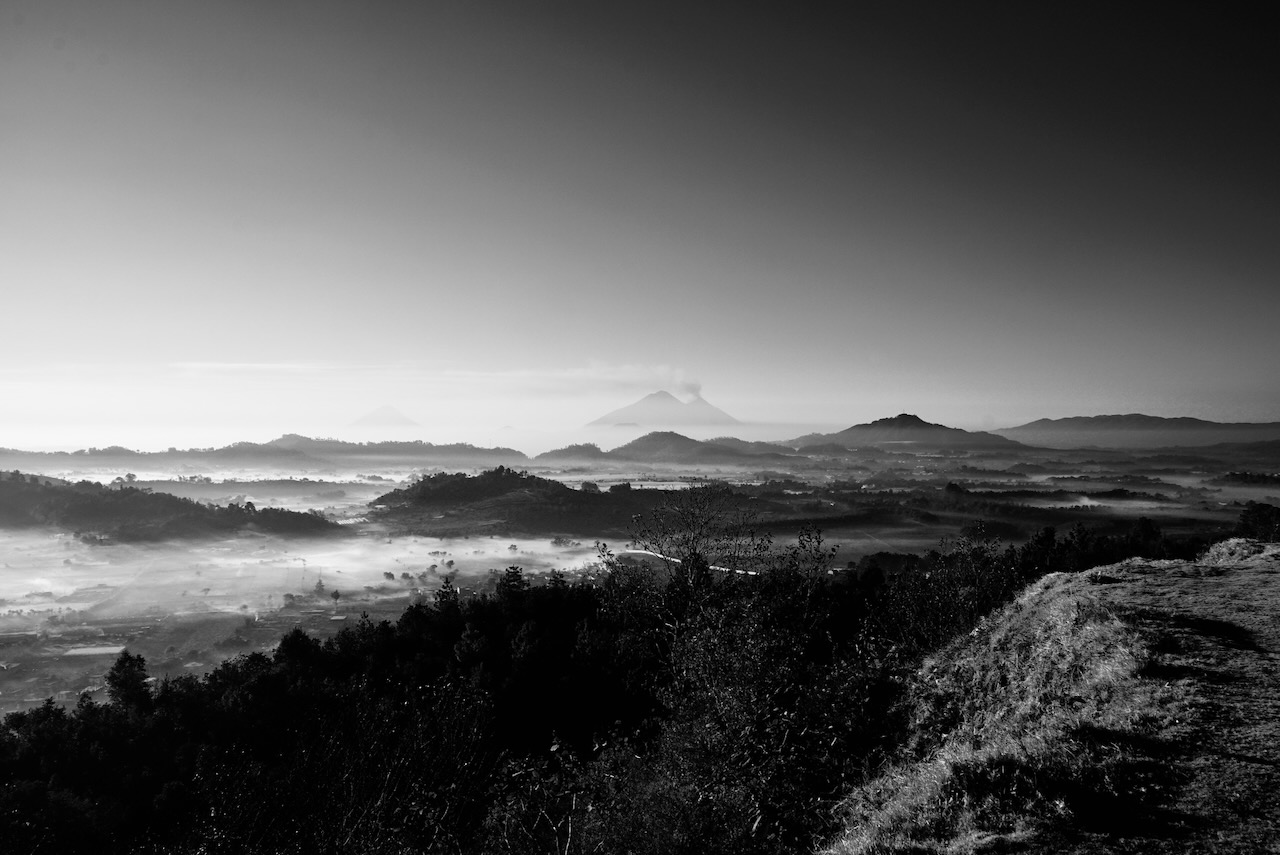 Volcanoes rising above a valley of morning mist