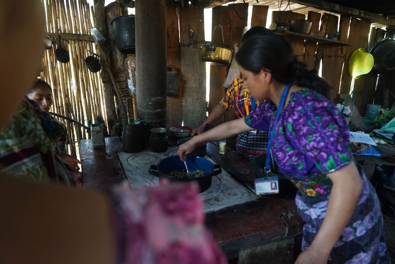 Women cooking on a wood stove in a timber kitchen