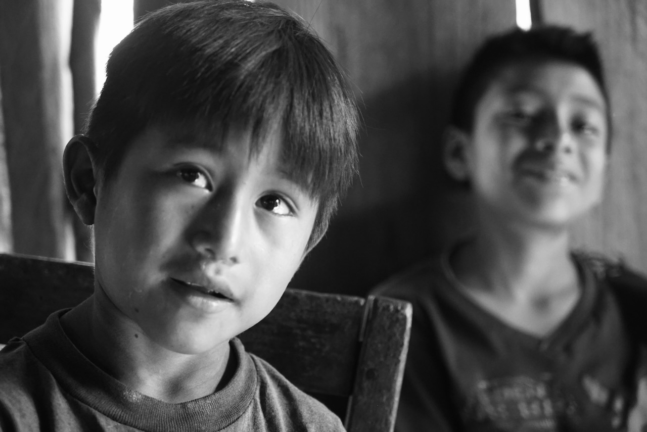 Two boys indoors, one looking toward the camera